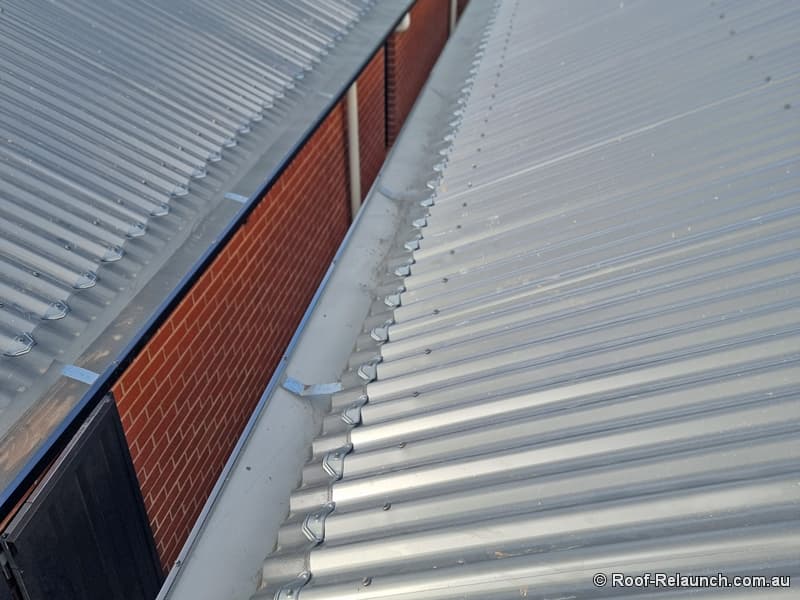 Top-down view of metal roof with newly-installed stainless steel mesh gutter guard
