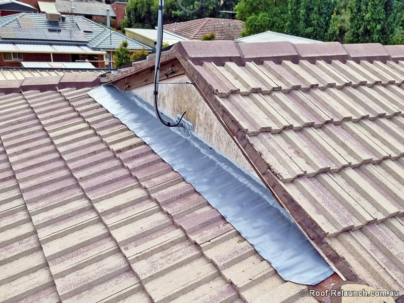 Roof with cleaned cement tiles and replaced lead flashing