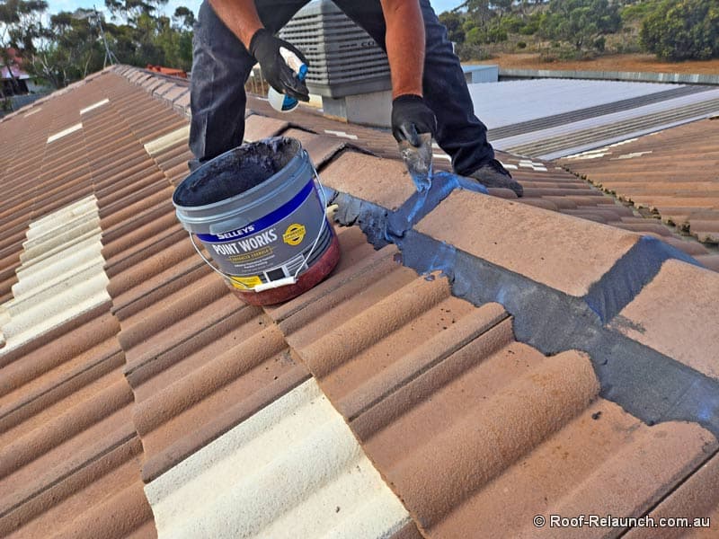 Roofer, repointing the ridge capping on tile roof