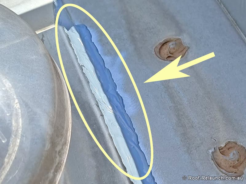 Closeup of metal house roof, showing fresh silicone applied to seal against leaking